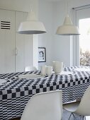 An arrangement of white crockery on a black and white checked tablecloth