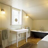 Vintage furniture in a bathroom in the attic of a country house with wood panelling