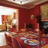 Ziegelrotes Esszimmer mit gedecktem Tisch und Blick auf Durchgang und offene Küche