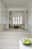 Minimalistische Wohnung mit Blick auf Holzstufen und Sofagarnitur im offenen Wohnraum
