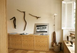 Sideboard mit Schubladen in hellem Holz und dekorierte Wand