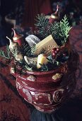 A red ceramic pot stuffed with Christmassy things