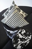 Patterned cushions in a black and white container with cover