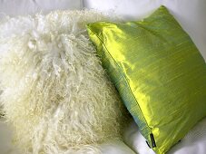 Two pillows with sheepskin cover and green silk