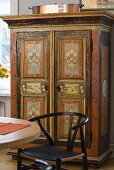 Painted farmhouse cabinet and black chair in a dining area