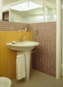 Pedestal washbasin in colourful tiled bathroom