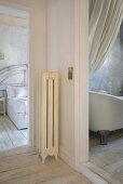A view from an anteroom through an open doors into a bathroom and a bedroom