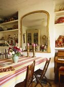 Flowers and candlesticks on table in country style dining room