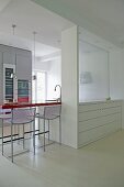 Bar stools at breakfast bar in modern kitchen