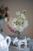 Dog figure and white flowers in vase