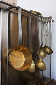 Copper cookware hanging beside oven