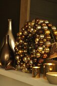 Wreath made of golden Christmas ball ornaments with tea light and vases in shiny metallic colors