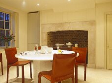 Kitchen round table and retro chairs in front of period fireplace.