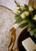 A detail of a traditional gilt armchair with embroidered upholstery,