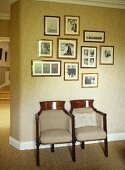 Display of black and white pictures above pair of old cinema seats