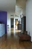 Open-plan living - an antique side table on parquet flooring