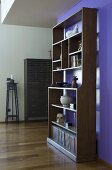 An antique bookshelf in front of a purple wall