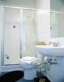 A white bathroom with a glazed shower cubicle