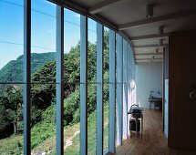 An open living room in a newly built house with a glass facade and a panoramic view