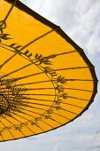 An open yellow sunshade with an oriental pattern