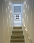 Schmales modernes Treppenhaus mit Licht- und Schattenspiele an Wand