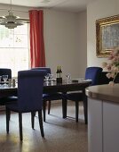 A dark wood dining table and blue upholstered chairs