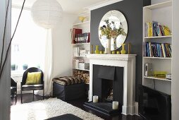 A black fireplace with a white mantelpiece and a bookshelf in a living room