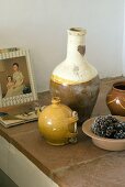 Vasen, Schälchen und Bücher auf einer Ablage