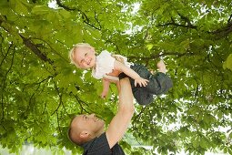 Vater hält die kleine Tochter in die Luft