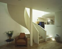 Brown retro leather chair in front of a winding staircase in a modern living room