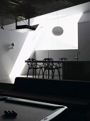 Hanging lamp above a dining area with designer chairs on a platform