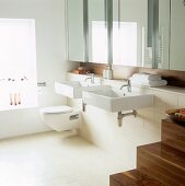 A modern bathroom with two washbasins and a mirrored cabinet
