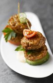 Meat patties, cucumber and tomato on cocktail sticks