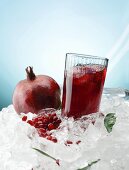 Pomegranate juice and a pomegrante on ice