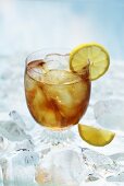 A glass of ice tea with lemons on ice