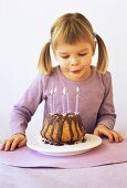 Girl blowing out candles on birthday cake