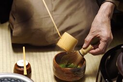 Tea master at tea ceremony, pouring water onto tea