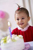 Kleines Mädchen mit Kokos-Kiwi-Torte zum Geburtstag