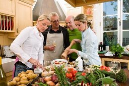 Two couples preparing food together