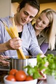 Young couple cooking spaghetti together