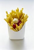 Pommes frites mit Ketchup und Mayo in weisser Fast-Food-Box