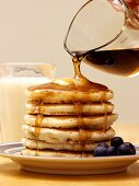 Pouring Syrup Over a Stack of Pancakes