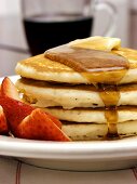 Pancakes mit Ahornsirup, Butter und Erdbeeren