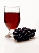 Glas Rotwein und blaue Trauben