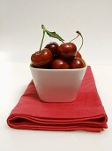 Dish of Red Cherries Resting on a Red Napkin