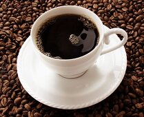 Tasse schwarzer Kaffee auf Kaffeebohnen