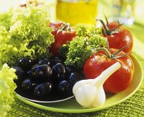 Salatzutaten: Tomaten, Knoblauch, Oliven und Lollo Biondo