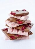 A stack of various pieces of chocolate with cranberries