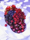 Fresh berries and cherries on a white plate