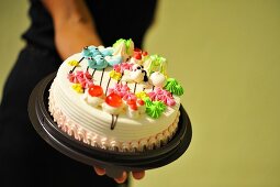 A woman holding a birthday cake